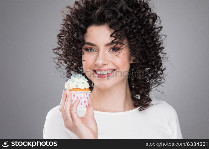 Happy woman with cake. Happy smiling woman with curly hair holding small cake