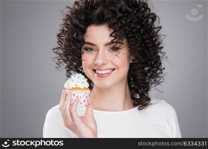 Happy woman with cake. Happy smiling woman with curly hair holding small cake