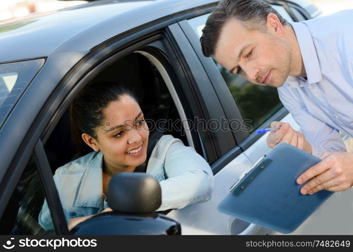 happy woman with car dealer in auto show or salon