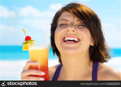 happy woman with colorful cocktail on the beach