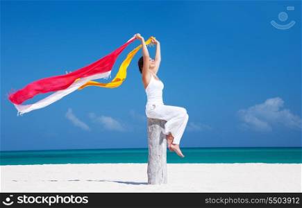 happy woman with colorful sarongs on the beach