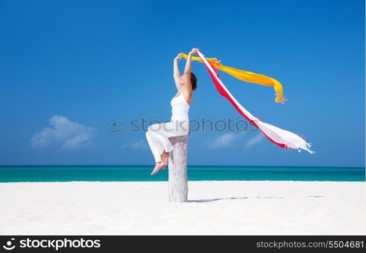 happy woman with colorful sarongs on the beach