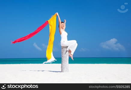 happy woman with colorful sarongs on the beach