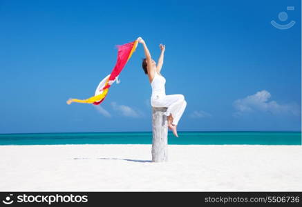 happy woman with colorful sarongs on the beach