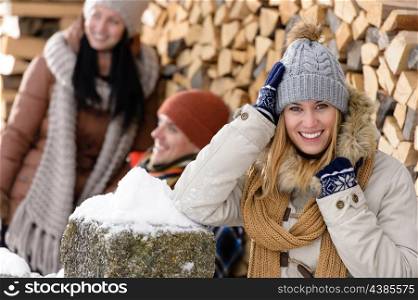Happy woman with friends smiling outside winter countryside cottage
