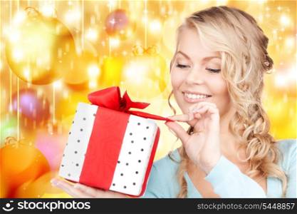 happy woman with gift box over christmas lights