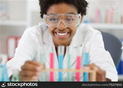 happy woman with glasses holds multicolored liquids