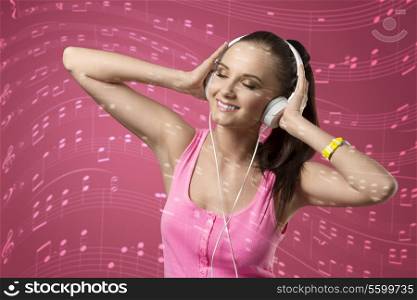 happy woman with headphone listening music and smiling, wearing pink singlet