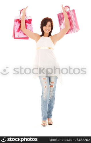 happy woman with pink shopping bags over white