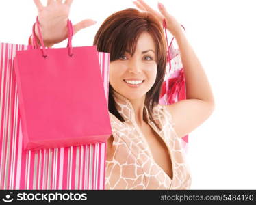 happy woman with pink shopping bags over white