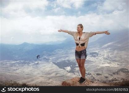 Happy woman with raised up hands of joy and fun enjoying an amazing view. Spending summer vacation hiking in the mountains.. Happy woman in the mountains