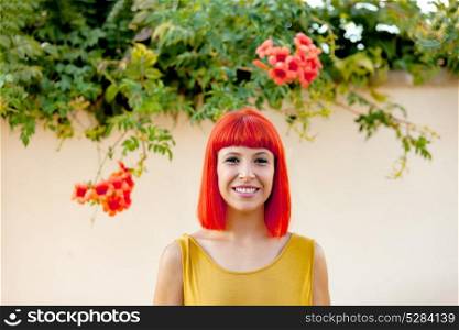 Happy woman with red hair and yellow dress near to a plant with beautiful flowers