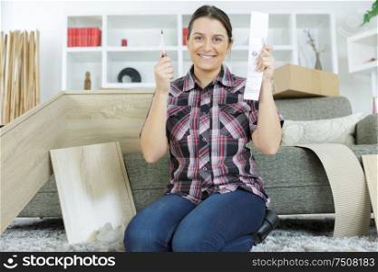 happy woman with self assembly furniture in kitchen