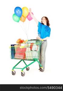 happy woman with shopping cart and balloons over white