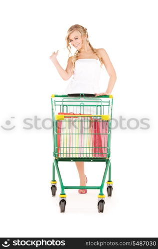 happy woman with shopping cart over white