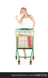 happy woman with shopping cart over white