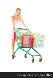 happy woman with shopping cart over white