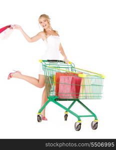 happy woman with shopping cart over white