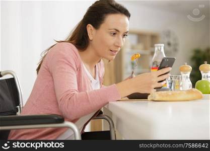 happy woman with smartphone eating at home