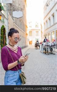 Happy woman with smartphone in european street. Young attractive tourist outdoors in Vienna city. Woman talk by her smartphone in city. Young attractive tourist outdoors in italian city