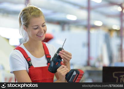 happy woman with toolbelt and drill