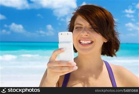 happy woman with white phone on the beach