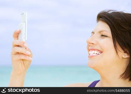 happy woman with white phone on the beach