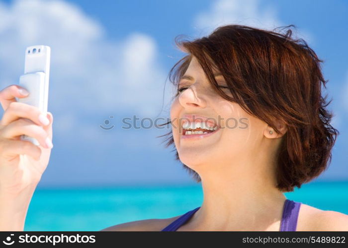 happy woman with white phone on the beach