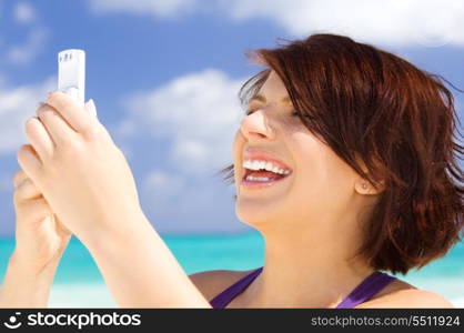 happy woman with white phone on the beach