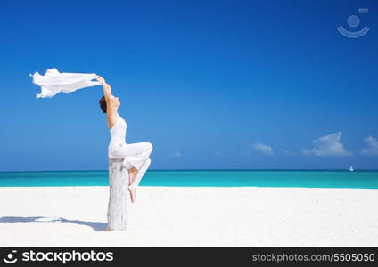 happy woman with white sarong on the beach