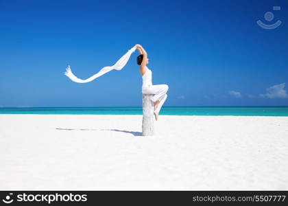 happy woman with white sarong on the beach