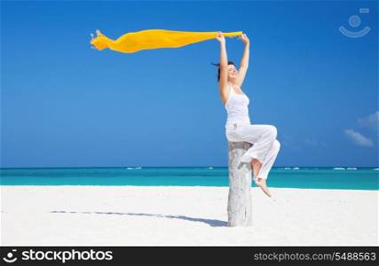 happy woman with yellow sarong on the beach