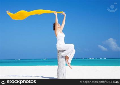 happy woman with yellow sarong on the beach