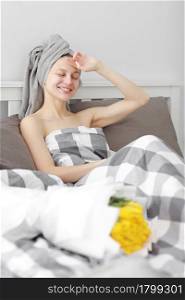 happy woman with yellow tulip flowers in bed after shower with towel on head enjoying romantic gift for valentines day. gave her a bouquet of flowers. Birthday, women&rsquo;s day. happy woman with yellow tulip flowers in bed after shower with towel on head enjoying romantic gift for valentines day. gave her a bouquet of flowers. Birthday, women&rsquo;s day,