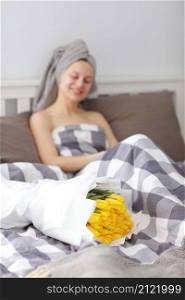 happy woman with yellow tulip flowers in bed after shower with towel on head enjoying romantic gift for valentines day. gave her a bouquet of flowers. Birthday, women&rsquo;s day. happy woman with yellow tulip flowers in bed after shower with towel on head enjoying romantic gift for valentines day. gave her a bouquet of flowers. Birthday, women&rsquo;s day,