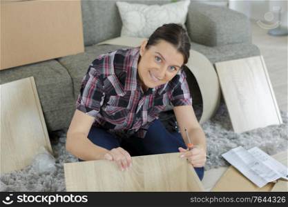 happy woman wooden furniture assembling