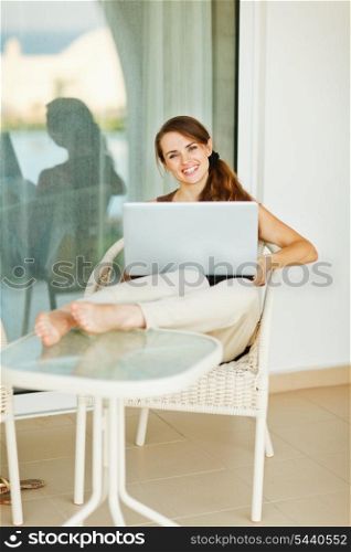 Happy woman working on laptop on vacation