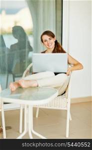 Happy woman working on laptop on vacation