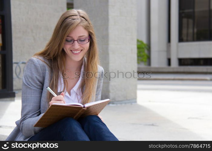 Happy woman writing in her notebook