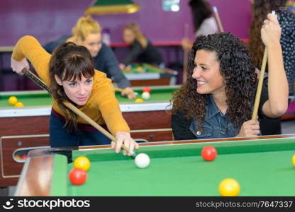 happy women are playing pool