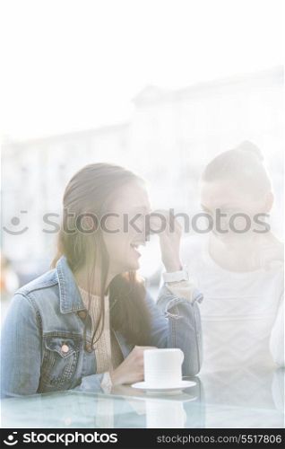 Happy women at sidewalk cafe during winter