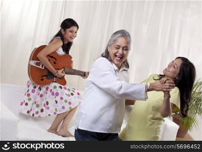 Happy women dancing while girl playing guitar