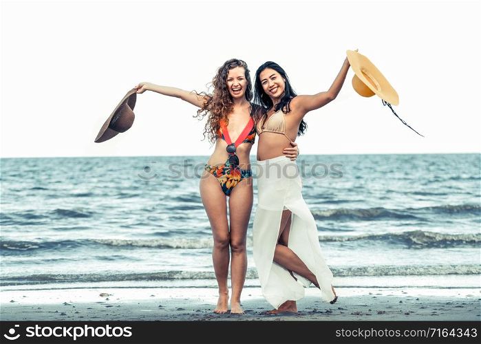 Happy women in bikinis dance together on tropical sand beach in summer vacation. Travel lifestyle.. Happy women dance on sand beach in summer.