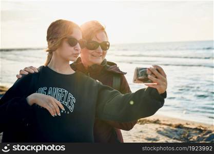 Happy women making video call on smartphone during trip on summer vacation. Taking selfie photos