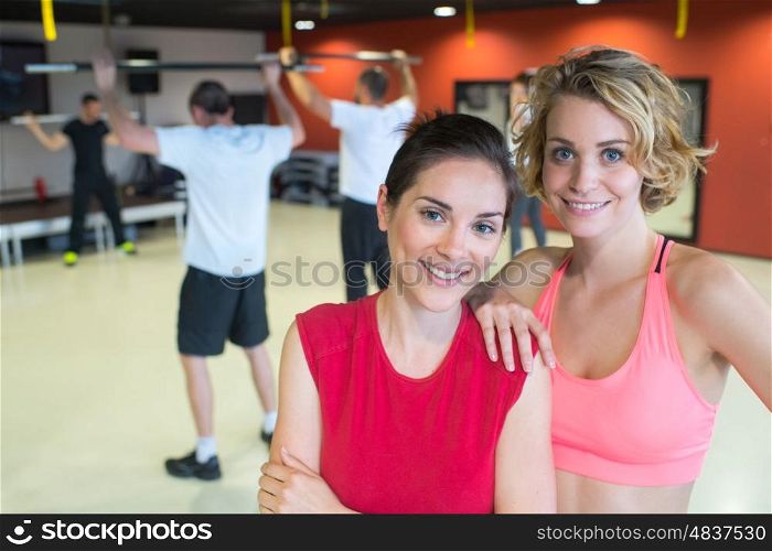 happy women posing in a gym and smiling