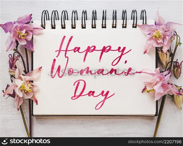 Happy Women&rsquo;s Day. Greeting card with a congratulatory inscription and and bright flowers. Close up, indoor, studio photo. Congratulations for family, loved ones, friends and colleagues. Happy Women&rsquo;s Day. Greeting card with a congratulatory inscription