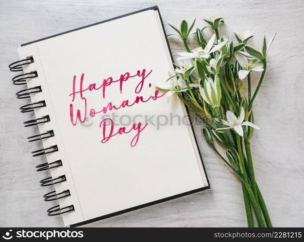 Happy Women&rsquo;s Day. Greeting card with a congratulatory inscription and and bright flowers. Close up, indoor, studio photo. Congratulations for family, loved ones, friends and colleagues. Happy Women&rsquo;s Day. Greeting card with a congratulatory inscription