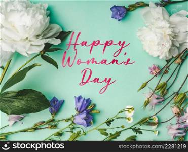 Happy Women&rsquo;s Day. Greeting card with a congratulatory inscription and and bright flowers. Close up, indoor, studio photo. Congratulations for family, loved ones, friends and colleagues. Happy Women&rsquo;s Day. Greeting card with a congratulatory inscription