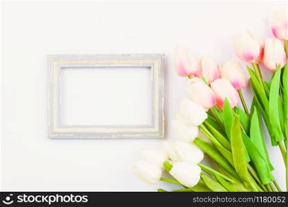 Happy Women&rsquo;s Day, Mother&rsquo;s Day and Valentine&rsquo;s Day concept. top view flat lay Tulip flower and photo frame on white background, copy space for your text