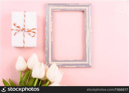 Happy Women&rsquo;s Day, Mother&rsquo;s Day concept. top view flat lay photo frame, gift box and Tulip flower on pink background, copy space for your text